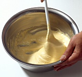 Dough being beaten vigorously in bowl