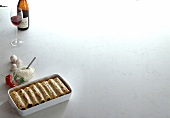 Cannelloni with meat filling in baking dish on white background, copy space