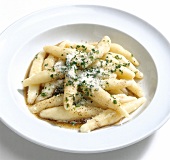 Potato noodles garnished with butter, herbs and parmesan on plate