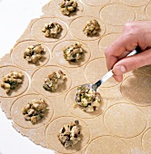 Filling being put on round cut cookie dough