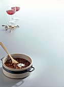 Two wine glasses with hare sauce in pot on white background