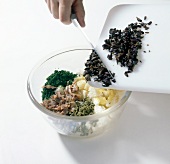 Ingredients for filling being added in bowl for preparing stuffed pepper, step 3