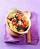 Baked potato with tomatoes, spinach and gorgonzola cheese in serving bowl