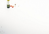 Bottle of wine, halved tomato and spice on white background