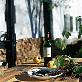 Elderberry with quince and wine bottle on wooden table