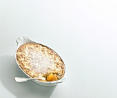 Apricot rice with apricots and macaroons in serving dish with spoon