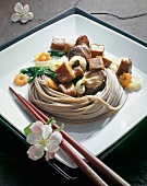 Close-up of soba noodles with tuna in serving dish