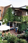 Haus mit Terrasse und Fassade mit wildem Wein bewachsen