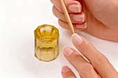Close-up of woman manicuring nails with rosewood cuticle