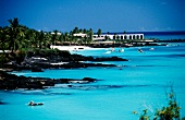 Bucht an der Küste der Komoren mit Hotelanlage, Booten, Urlaubern