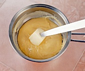 Soufflemasse and butter in souffle dish with knife