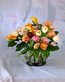 Rosen, Tulpen und Ranunkeln in einem Glasvase mit Drahtgitter befestigt