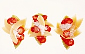Appetizers of melon and strawberry salad with grated coconut on white background