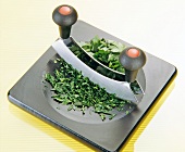Close-up of parsley finely chopped with a mezzaluna in bowl