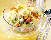 Potato salad with spring onions, cucumber, tomatoes and alfalfa sprouts in glass bowl