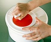 Close-up of woman's hands spinning dry lettuce in a salad spinner