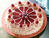 Close-up of butter cream cake with raspberries on plate