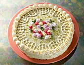 Close-up of cake with pistachio buttercream decorated with colourful sugar flowers