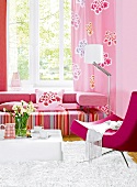 Living room with pink striped sofa, armchair and floral pattern curtain