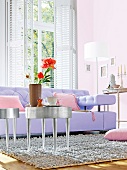 Purple sofa with pink cushions and silver coffee table in living room
