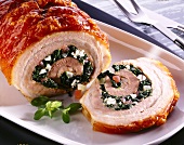 Close-up of pork roulade with spinach, cheese, tomato, garlic and onion filling