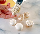 Close-up of woman's hands brushing mushrooms with a brush