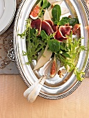 Winter salad with pears and figs on serving dish and spoons