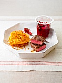 Lamb with cranberry chutney and hash browns on serving plate