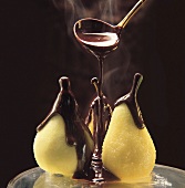 Drei Birnen werden mit heißer Schokoladensauce begossen
