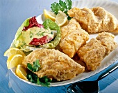 Cod fillet with crispy sesame crust, mayonnaise, salad and lemon on plate