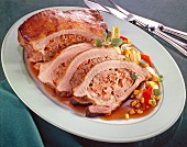 Spicy veal breast stuffed with liver and bell pepper and sweet corn on plate