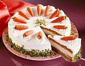 Sponge cake of carrots, pistachio and lemon cream with piece of cake on spatula