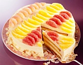 Sponge cake with orange cream and fruits on plate