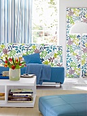 Wohnraum mit Sofa, florale Muster Stoffe, gestreifte Vorhänge