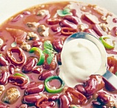 Close-up of bean stew with ground beef, chilli peppers, tomatoes and cream