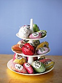 Close-up of advent calendar cake stand with multi-coloured paper mache cones and nuts