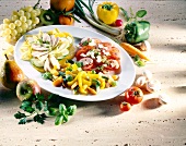 Three salads on plate surrounded with fruits and vegetables