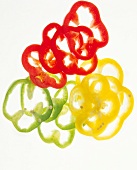 Red, yellow and green pepper slices on white background