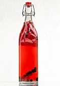 Red vinegar with onions peppers and capers in a bottled flask