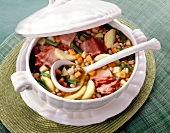 Bacon, potatoes, carrots and onions soup in tureen bean pot with ladle