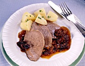 Beef with potatoes and plum sauce on plate