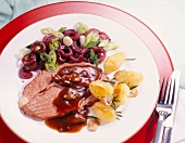 Hohe Rippe mit Rotwein-Zwiebeln und Rosmarinkartoffeln auf Teller