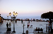 Tourist enjoying sunset at promenade in Taormina, Sicily, Italy