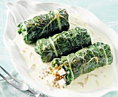 Chard rolls with wheat grains, onions, tofu and cream sauce in serving dish
