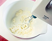 Vanilleeis in einer Schüssel mit dem Mixer cremig rühren, Step 4