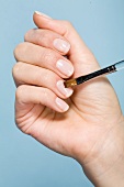Close-up of woman applying gel on nails with brush