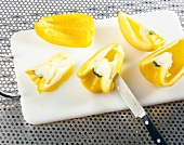 Removing seeds of yellow bell pepper on chopping board
