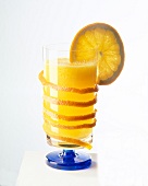 Ein Glas Orangensaft mit einer Orangenscheibe am Glasrand