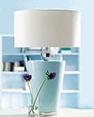 Lampe mit weißem Lampenschirm und und hellblauem Lampenfuß