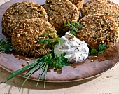 Close-up of sesame burgers on cream cheese with parsley and chives on plate